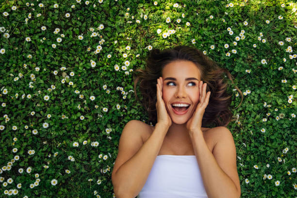 istock Smiling Young Woman Lying Down On Grass 2161960394