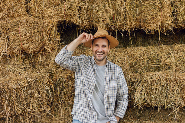 istock Smiling Farmer with Straw Hat by Hay Bales 2161960852