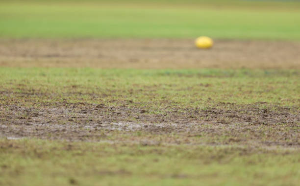 Wet football pitch with an AFL football in the background