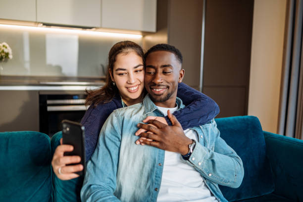 istock Diverse millennial couple in modern apartment using phone for video calling 2161969706