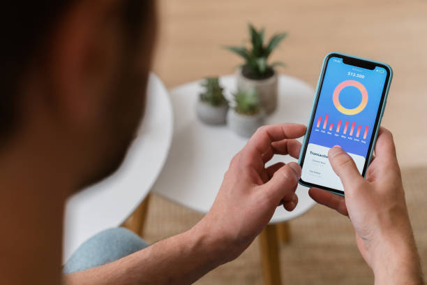 istock Man managing finances checking transactions history on smartphone app at home 2161969988