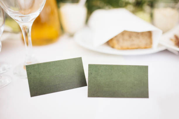 Elegant green cardboard place cards with empty copy space on a wedding table. Perfect for personalized guest seating arrangements.