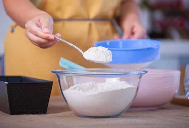 istock Young woman hands sieving flour, baking bread at home 2161971669