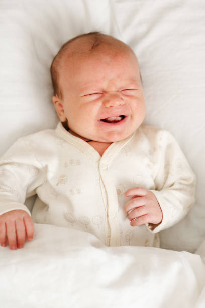 istock Baby boy lying crying in bed sleeping 2161973652