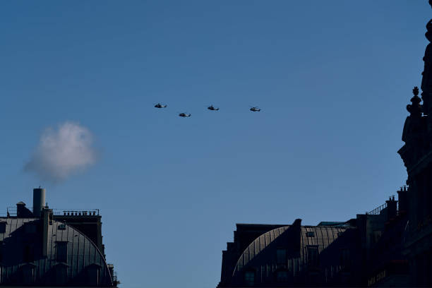 A stunning aerial display as planes fly in formation over the iconic city of Paris during the Bastille Day parade on July 14, 2024. The French Air Force jets leave vibrant trails of blue, white, and red smoke, representing the national colors of France, as they soar above famous landmarks such as the Eiffel Tower, the Arc de Triomphe, and the Champs-Élysées. Crowds of spectators can be seen below, gazing upwards in awe, celebrating Fête Nationale with a sense of pride and patriotism. This image captures the grandeur and excitement of France's national holiday, showcasing the skill and precision of the pilots and the festive atmosphere of Paris.