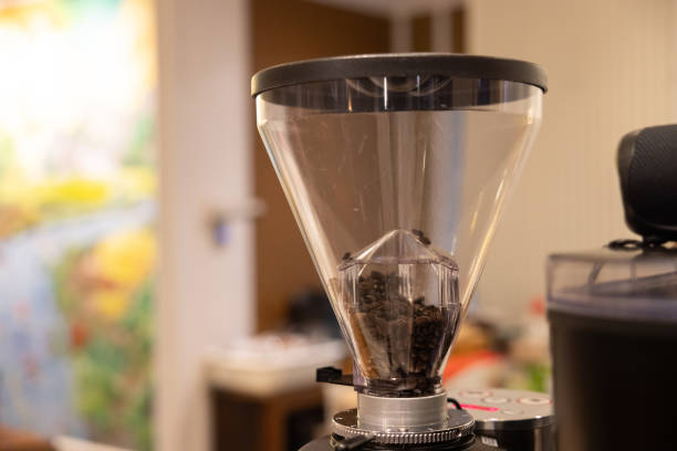 A coffee grinder with a small amount of coffee beans inside