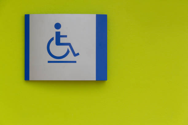 A sign with a man in a wheelchair on it. The sign is blue and white