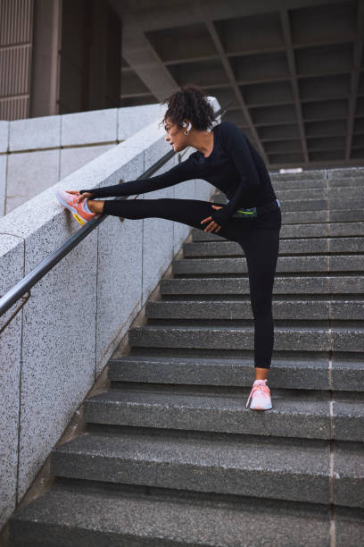 istock Low angle view of young female athlete warming up before workout on staircase 2161977034