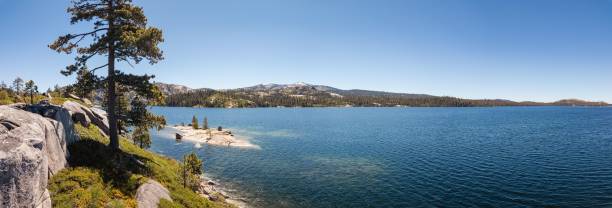 istock View of a clear blue lake surrounded by pine trees and mountains under a bright blue sky 2161977902