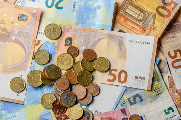 istock Euro bills and coins scattered on the table as a background 19 2161979024