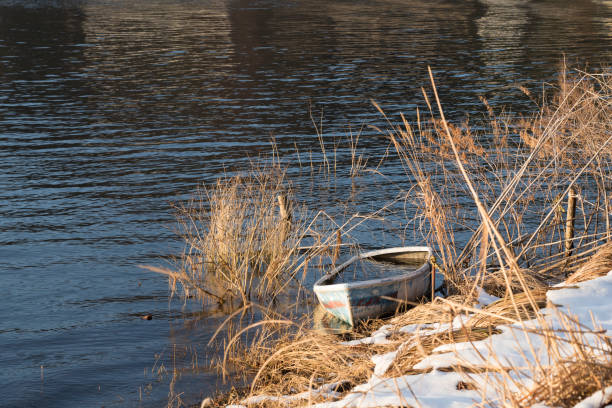 Abandoned boat by the lake in winter