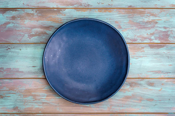Empty blue plate on old shabby wooden table. Top view, with copy space