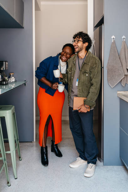 istock Co-workers laughing and bonding during a coffee break in the office 2161985117