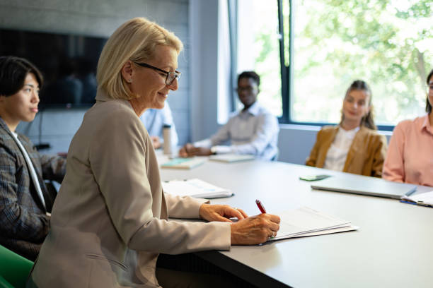 istock Business leadership: a senior director reviews a document during a meeting 2161994020