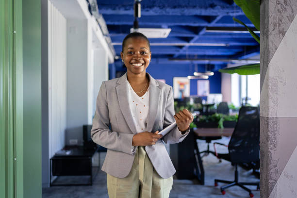 istock Smiling young black woman leader with tablet in modern office. 2161996083