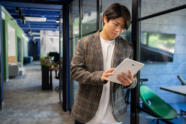 istock Young leader in open office space uses tablet for new ideas 2161996137
