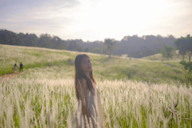 Asian girl walking in the middle of a field of flowers