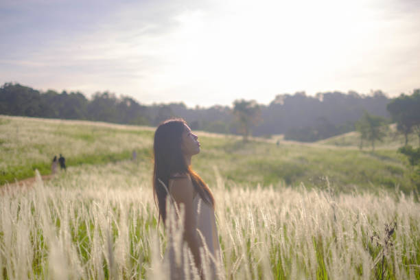 Asian girl walking in the middle of a field of flowers