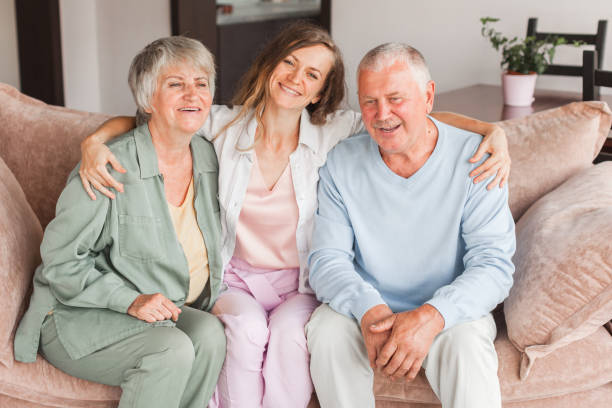 istock Defferent generation family hugging sit on sofa enjoy time together at home, laughing grown up daughter with dad and mom 2162006331