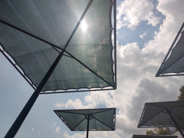 Sun umbrellas on the beach at cloudy blue sky