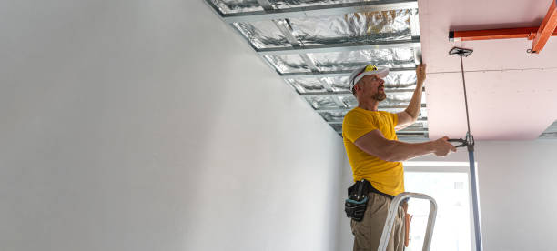 istock The worker picks up a plasterboard to the ceiling. He is using special drywall lift. A red plasterboard improve the fire resistance of ceiling structures. 2162013523
