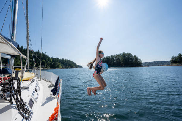 istock Young girl jumps from sailboat 2162013764