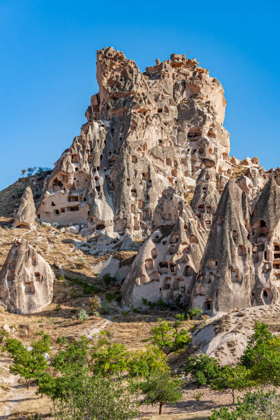 The Cappadocian plateau itself is composed largely of volcanic ash, with softer tufa intermixed with harder, more durable igneus rocks like basalt and andesite. The rocks of Cappadocia near Göreme eroded into hundreds of spectacular pillars and minaret-like forms. The volcanic deposits are soft rocks that the people of the villages at the heart of the Cappadocia Region carved out to form houses, churches, monasteries. Goreme, Cappadocia, Turkey, la meseta de capadocia en sí está compuesta en gran parte por cenizas volcánicas, con toba más blanda entremezclada con rocas ígneas más duras y duraderas como el basalto y la andesita. las rocas de capadocia, cerca de göreme, se erosionaron en cie