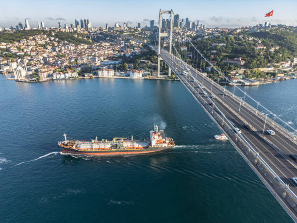 istock Aerial view of a cargo ship passing under bridge. Cargo Ship Beneath Bridge. 2162018478