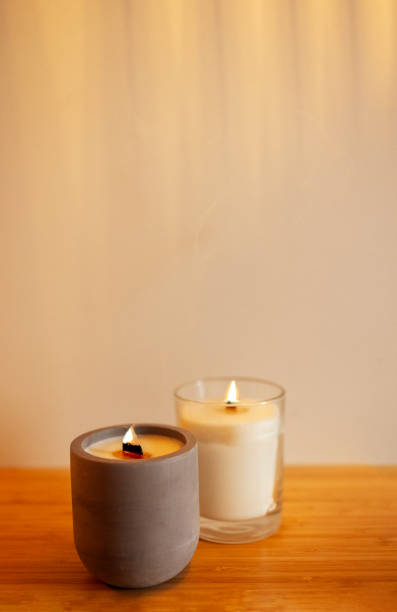 istock Two lighted candles in a ceramic and glass candlestick on a wooden table. 2162019871