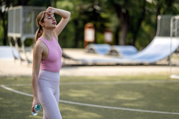istock Woman practicing yoga exercises on mat in public park. 2162022408