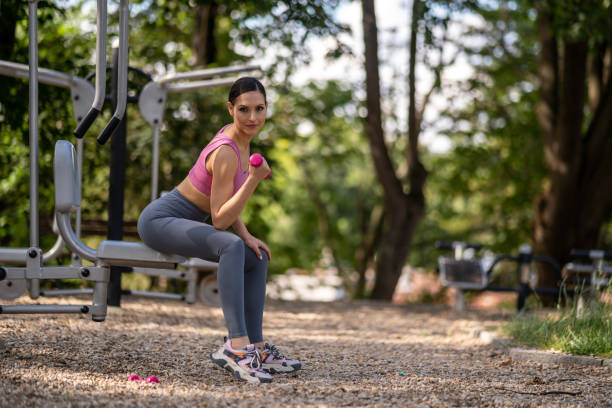 istock Woman practicing yoga exercises on mat in public park. 2162022445