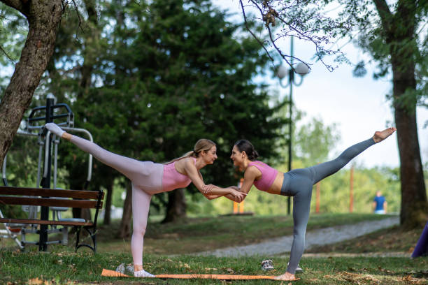 istock Woman practicing yoga exercises on mat in public park. 2162023379