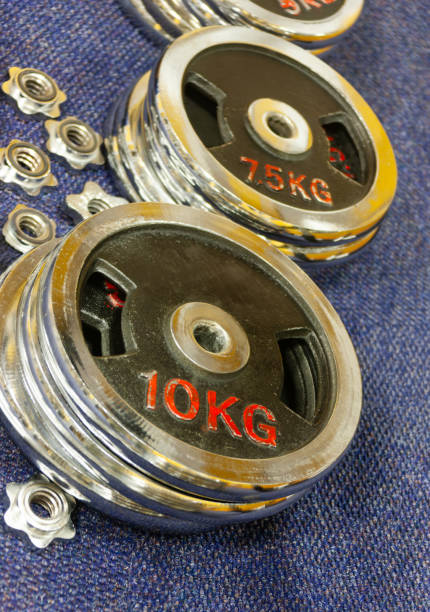 istock dumbbells, barbel disks various weights and lock nuts, change repair 2162024706