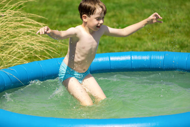 istock Cheerful 6 year old boy swimming in the pool 2162028711