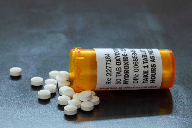 Prescription bottle with backlit Oxycodone tablets. Oxycodone is a generic prescription opioid. Prescription bottle with backlit Oxycodone tablets. Oxycodone is a generic prescription opioid. A concept of the opioid epidemic crisis Morphine Sulfate Tablet stock pictures, royalty-free photos & images
