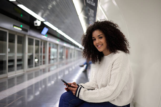 istock Young multiethnic woman using smartphone while waiting for subway train 2162030150