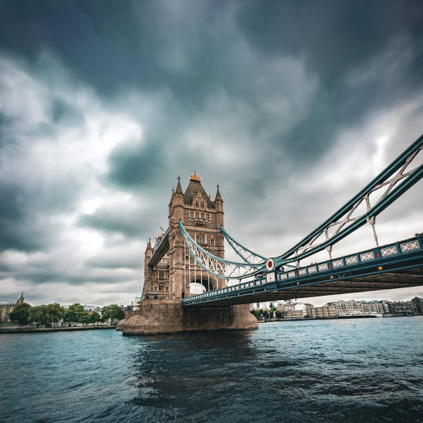 London, United Kingdom - June 30, 2023: The iconic Tower Bridge in London under dark blue sky before the storm.