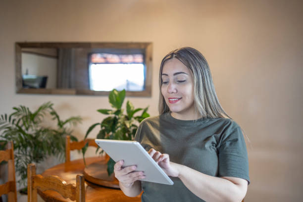 istock Latina woman controlling smart home environment with tablet 2162033193