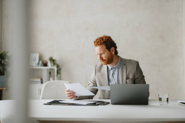 Businessman Reviewing Documents at Modern Office Desk
