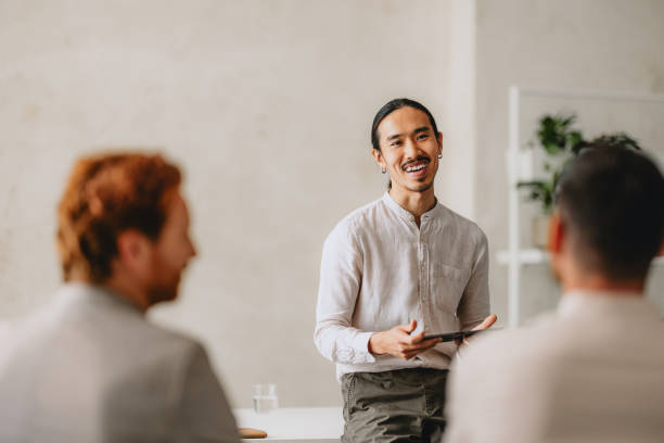 istock Smiling Leader Facilitating Group Business Meeting in Bright Office 2162033399