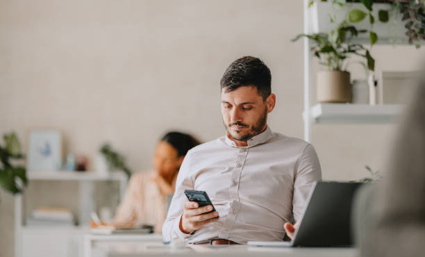 istock Businessman Working On Smartphone In Bright Modern Office 2162033434