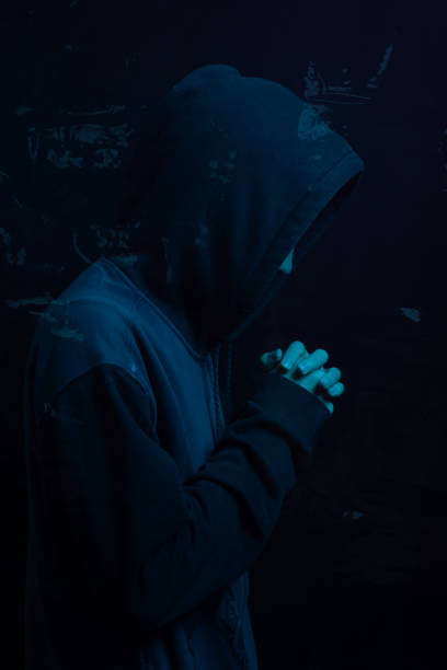 istock Young man wearing gray sweatshirt hiding his face. Studio portrait. 2162037257