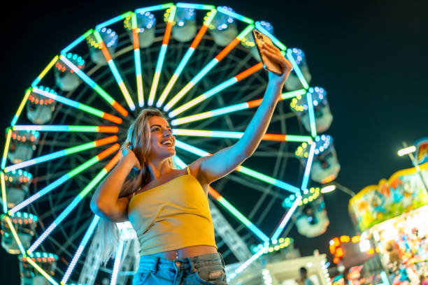 istock Woman making selfie at amusement park at night 2162038505