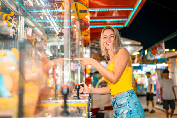 istock Woman playing arcade games at fair at night 2162038605