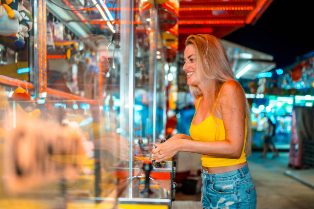 istock Woman having fun playing arcade games at fair at night 2162038613