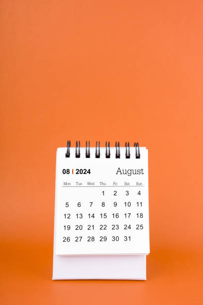 istock August 2024 table calendar on orange color background. 2162042770