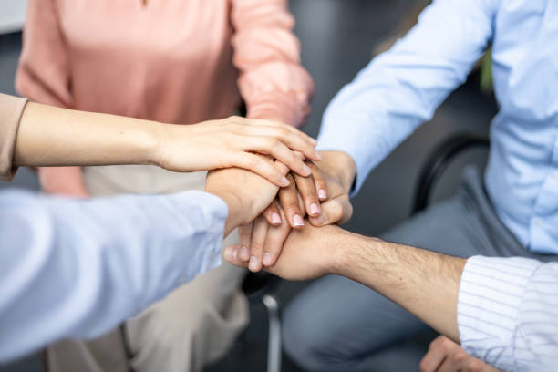 istock Small group of people in a circle stacking hands 2162042842