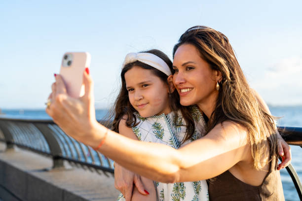 istock Mother and Daughter taking a selfie at sunset 2162051998