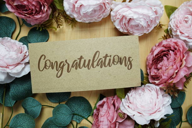 istock Congratulations text message on paper card with flowers border frame on wooden background 2162052068