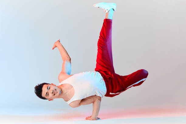 Hip-hop Korean break dancer in red sweat pants stay in white classroom all day and learn choreography done by other people, working out over technique. BBoy doing Chair Classic Freeze